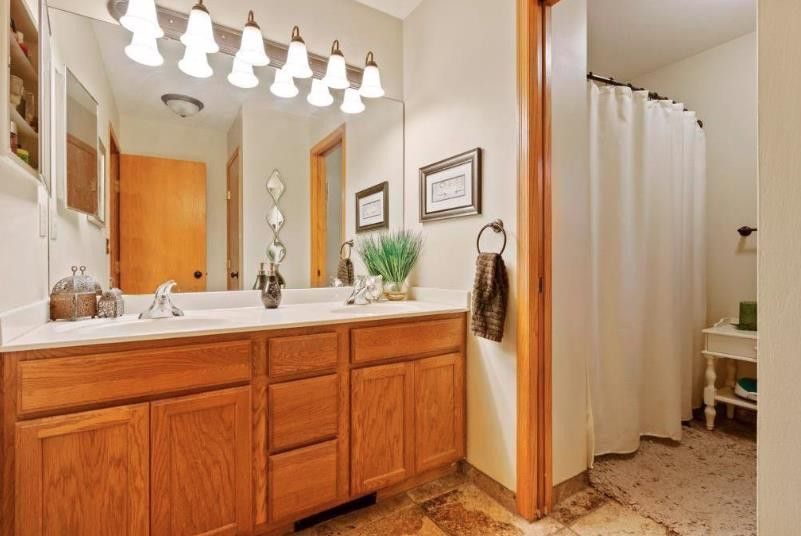 A bathroom with a wood vanity and mirror