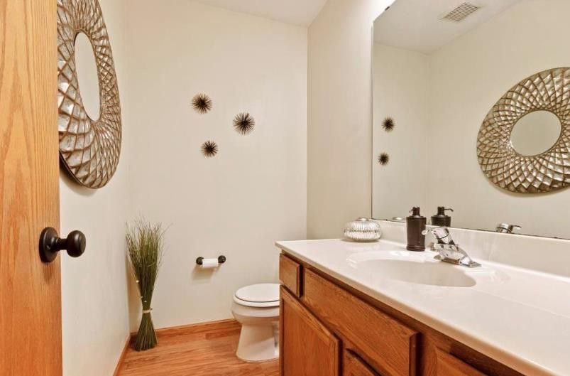 A half bathroom with vanity and mirror